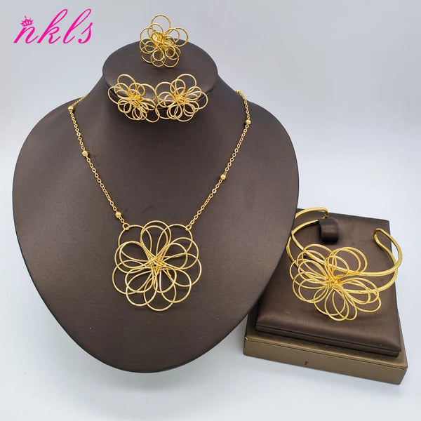 Juego de joyería floral chapada en oro para mujeres con delicados diseños de alambre, exhibido en un soporte oscuro.