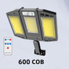 A black outdoor wall light fixture with three illuminated panels and a remote control.