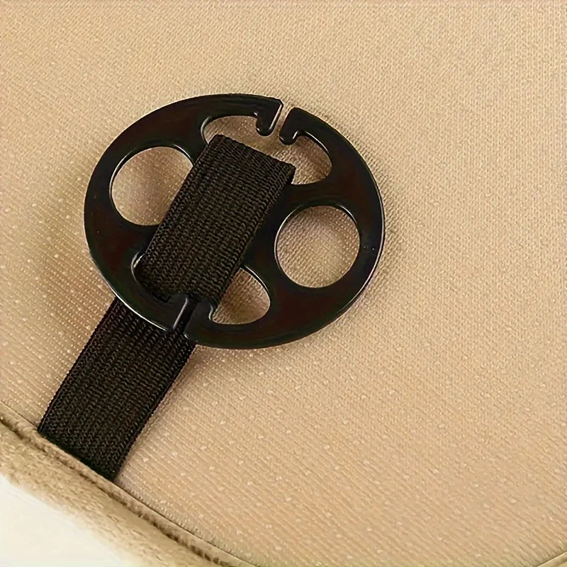 A black webbing strap and buckle attached to a beige plush winter car seat cover.