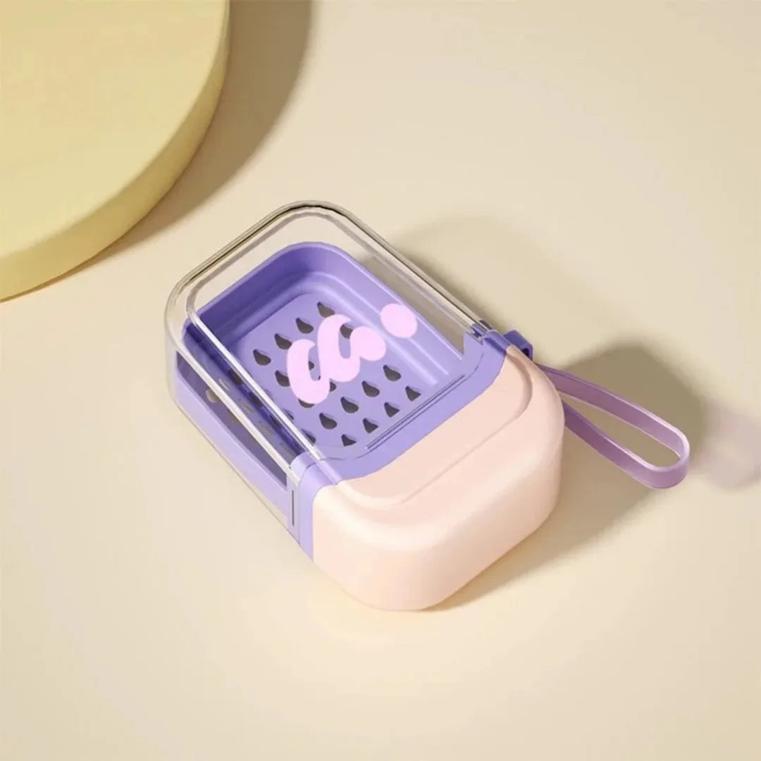 A purple and pink leakproof travel soap case with a secure lid is shown on a light background.