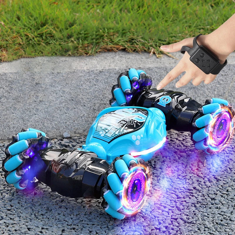A close-up of a black and blue RC stunt car with glowing purple lights being held by a hand outdoors.