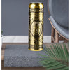 A gold-colored, cylindrical electric razor with a Buddha face design rests on a gray textured mat on a wooden surface.
