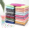 A collection of round imitation pearl beads in various colors and shades stacked on a white surface.