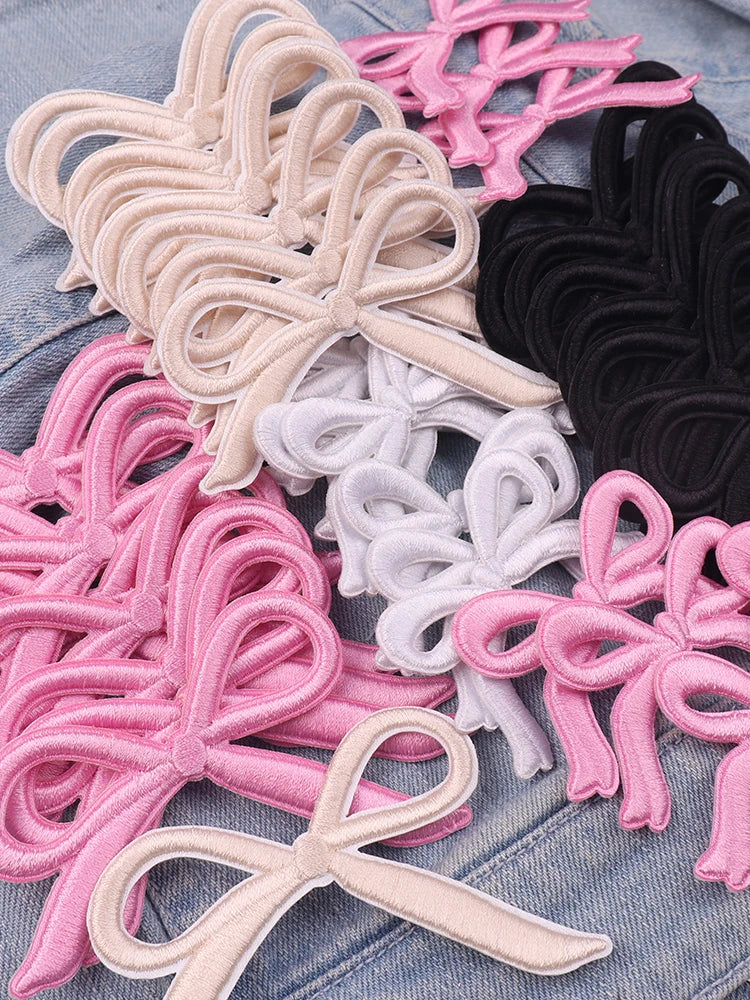 Assortment of pink, black, and white embroidered bow iron-on patches for DIY clothing decoration