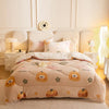 A beige plush throw blanket decorated with small pumpkin patterns is displayed on a bed.