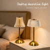 A brass-toned decorative table lamp with a textured glass shade sits on a light surface.