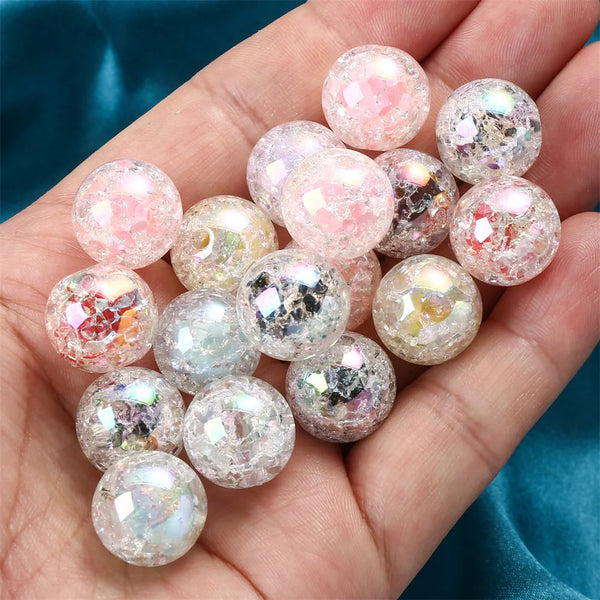 A hand holds a cluster of pink and iridescent glitter resin spacer beads.