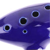 A close-up view of a deep blue ceramic ocarina with multiple holes and a glossy finish.