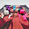Various colored roller tools for diamond painting arranged on a textured background.