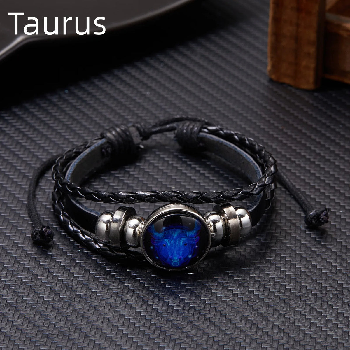 A black leather wrap bracelet featuring a blue gemstone charm and silver accents.
