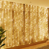 Golden sheer curtain fabric illuminated by warm fairy lights for home or party decor