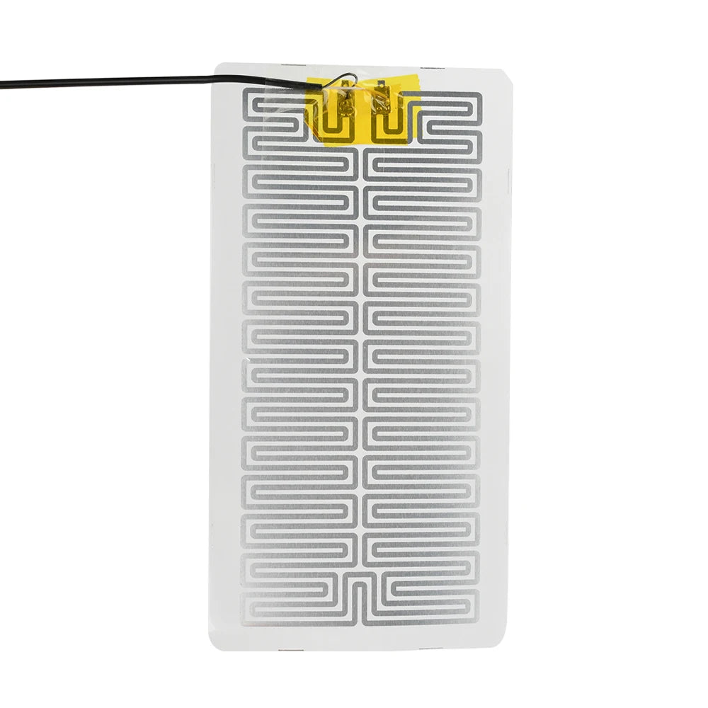 A white heating pad with yellow electrical contacts and a black wire, designed for desk or plant warmth.