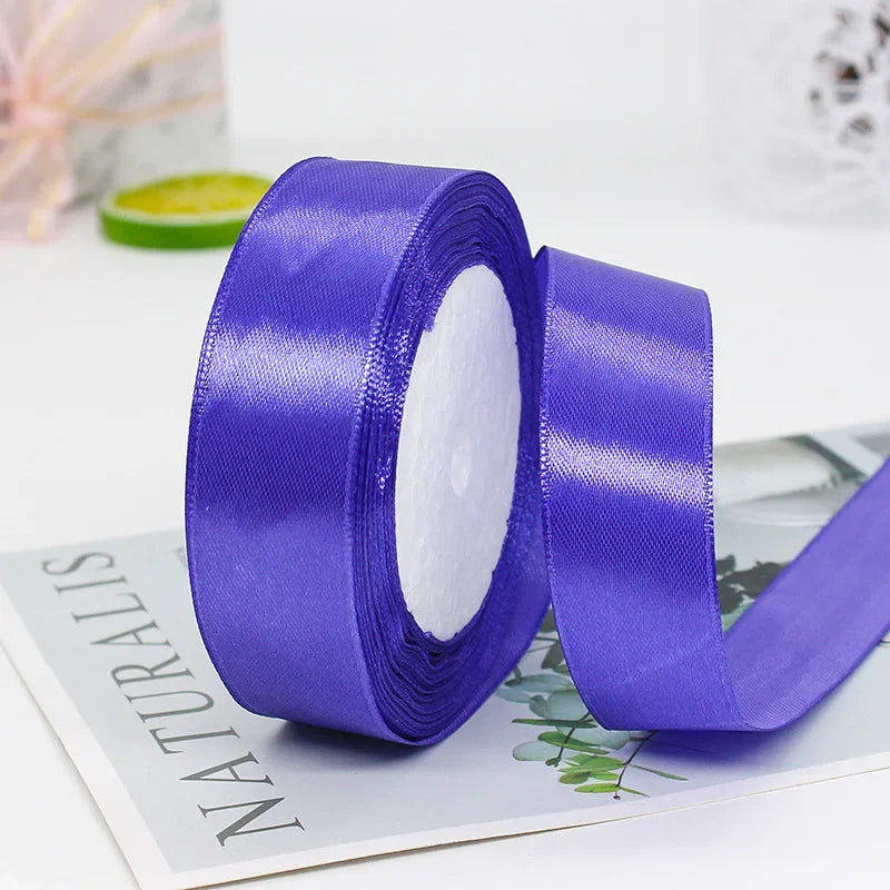 A roll of vibrant purple satin ribbon used for gift wrapping or DIY crafts.