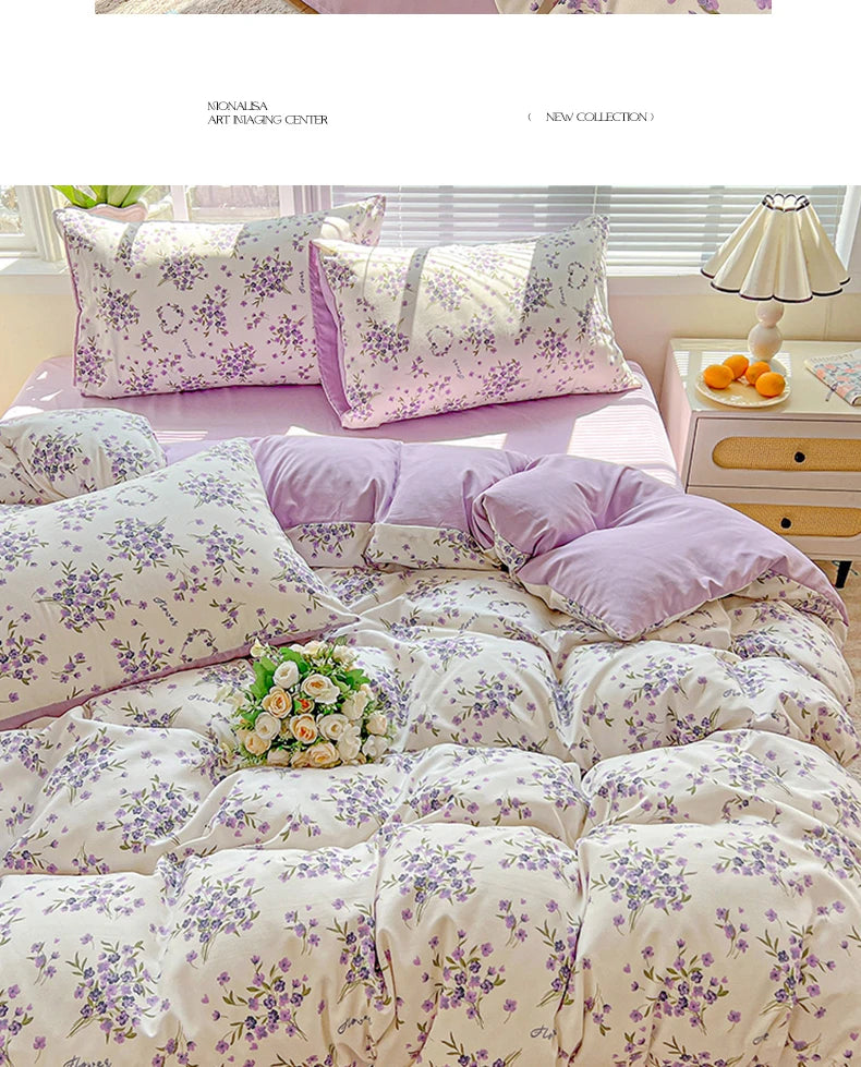 A set of floral duvet cover, flat sheet, and pillowcases in lavender and white floral patterns displayed on a bed.