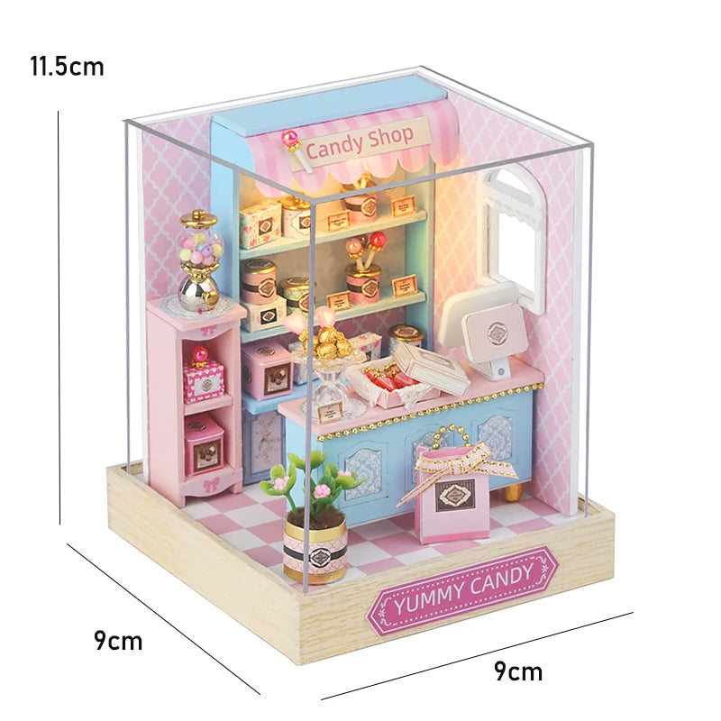 A miniature candy shop diorama kit featuring pink and blue structures with various shelves and items.