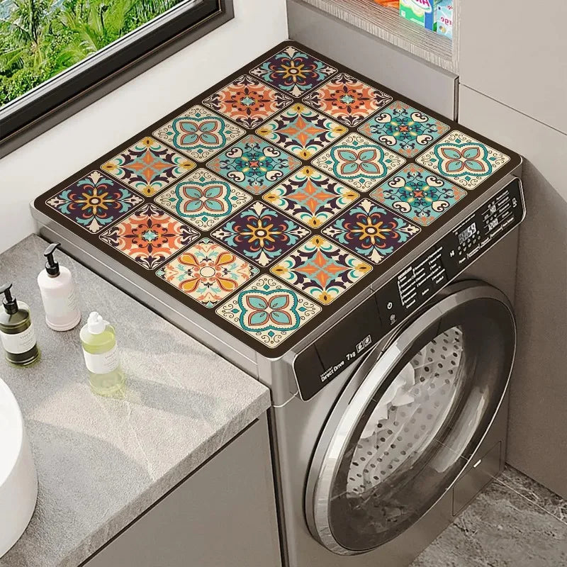 A close-up view of a stainless steel washing machine with a floral print absorbent protective mat installed on the top surfac