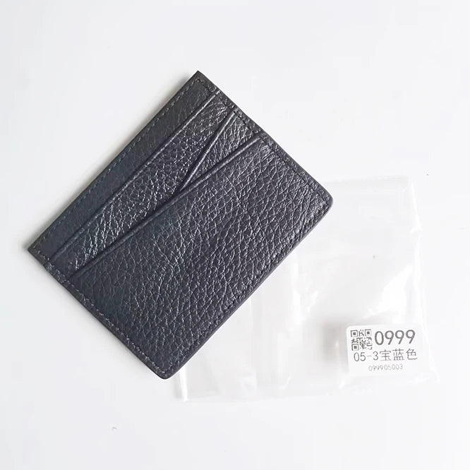 A black genuine leather slim card holder wallet is shown diagonally against a white background.