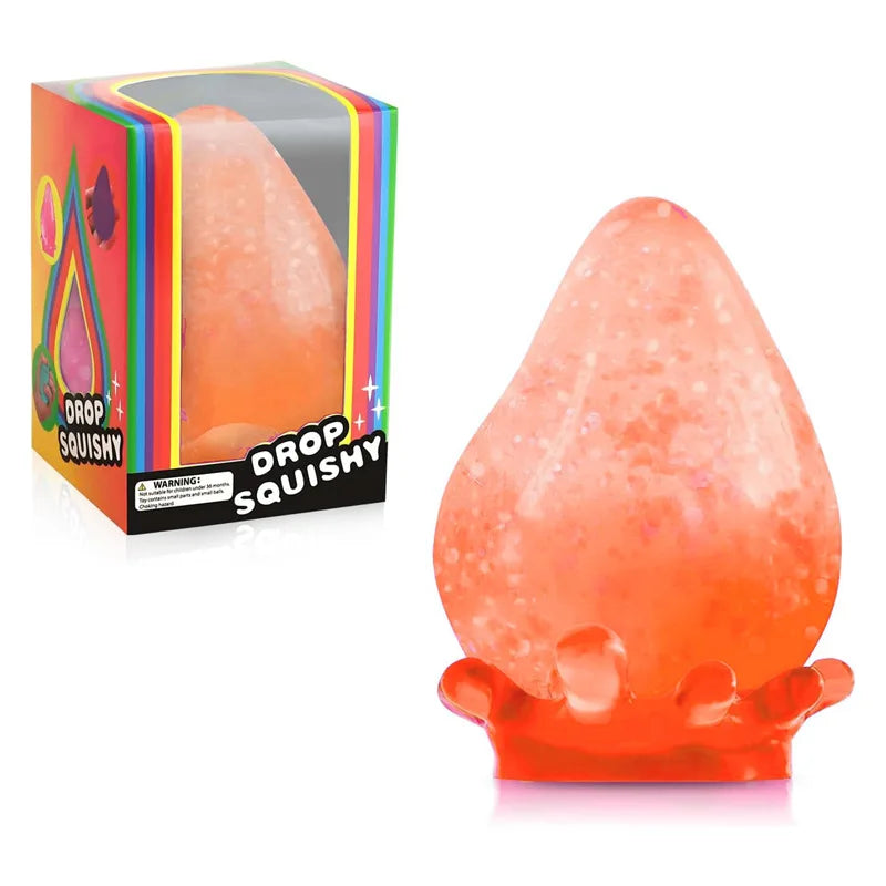 Durchsichtiger orangener Stressball in Tropfenform neben seiner Verpackung