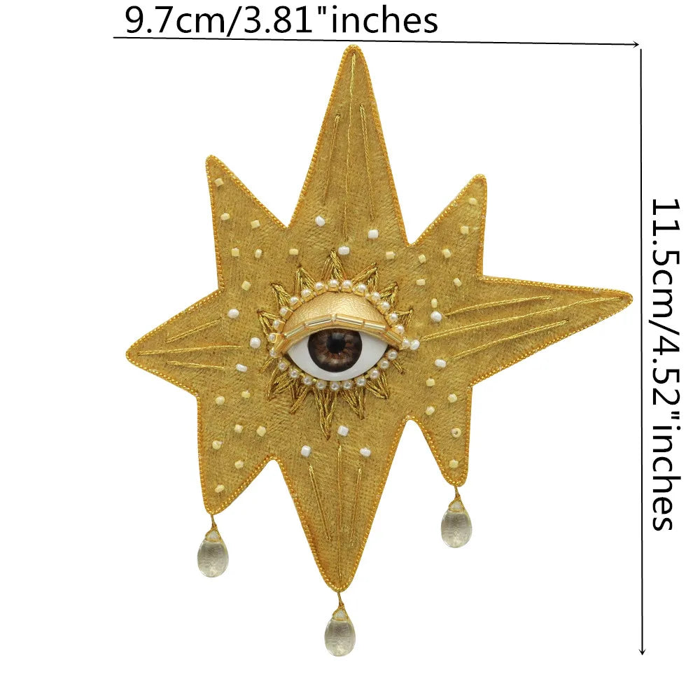 Gold star-shaped patch with a central eye design and dangling beads