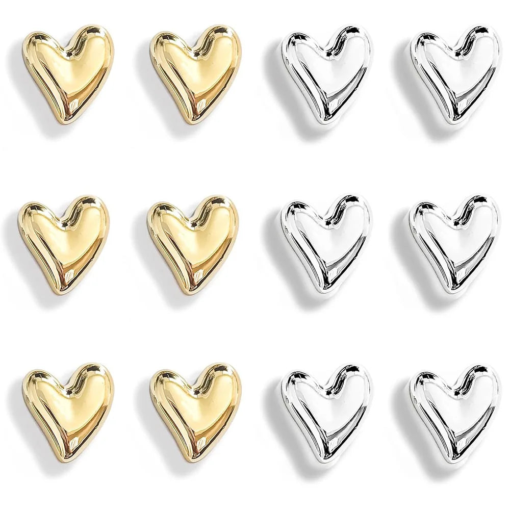 A set of twelve gold and silver mini heart-shaped refrigerator magnets.