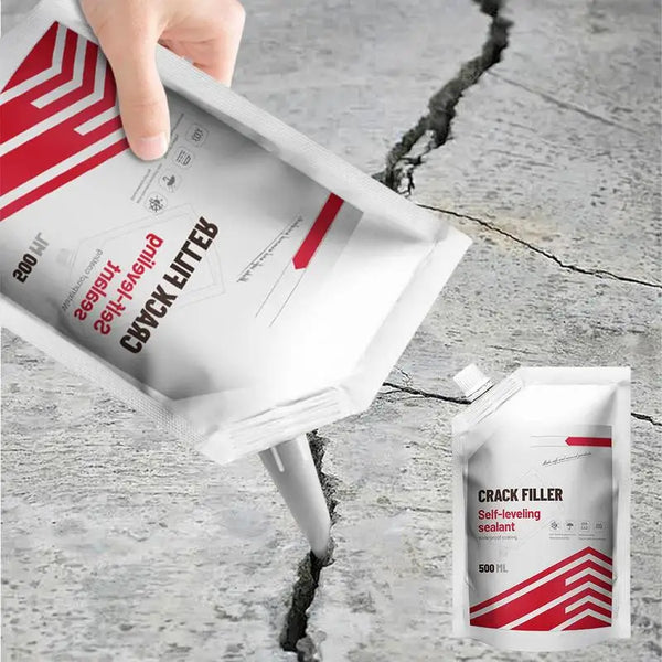 Una mano aplica un tubo de sellador de relleno de grietas blanca en una fisura de concreto sobre una superficie gris.