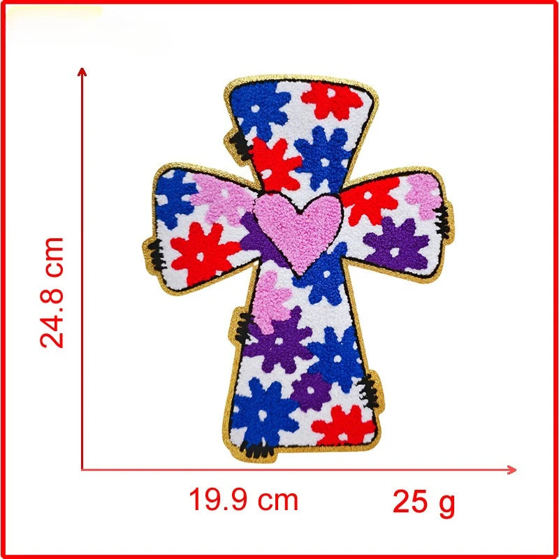Embroidered cross patch with a pink heart and floral design on a white background