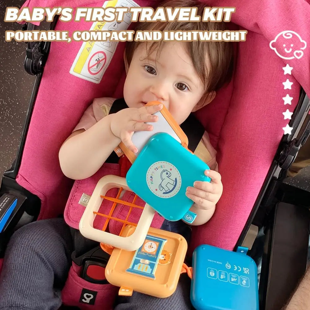 A baby is holding a blue sensory cube and an orange tray inside a pink travel kit.