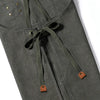 A close-up of a dark olive green cotton canvas apron with drawstring ties and cross-back straps.