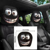 A pair of black horror-themed car headrest covers featuring creepy smiling faces.