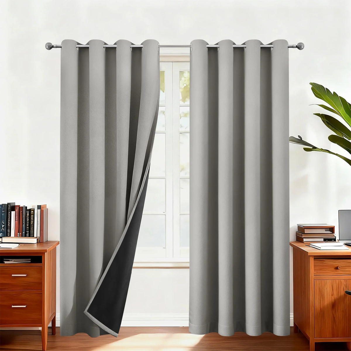 Gray double-layer blackout curtains hanging in a window frame with natural light.