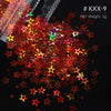 A pile of shiny holographic star sequins in various colors like red, orange, green, and purple on a dark surface.