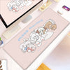 A pink kawaii cartoon desk mat featuring fluffy white rabbits and a brown bear character.