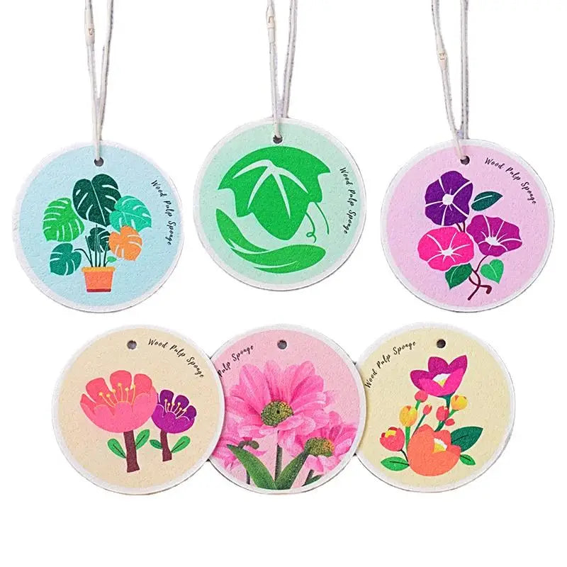 A set of ten eco-friendly wood pulp dish sponges shaped like various green and pink flowers.