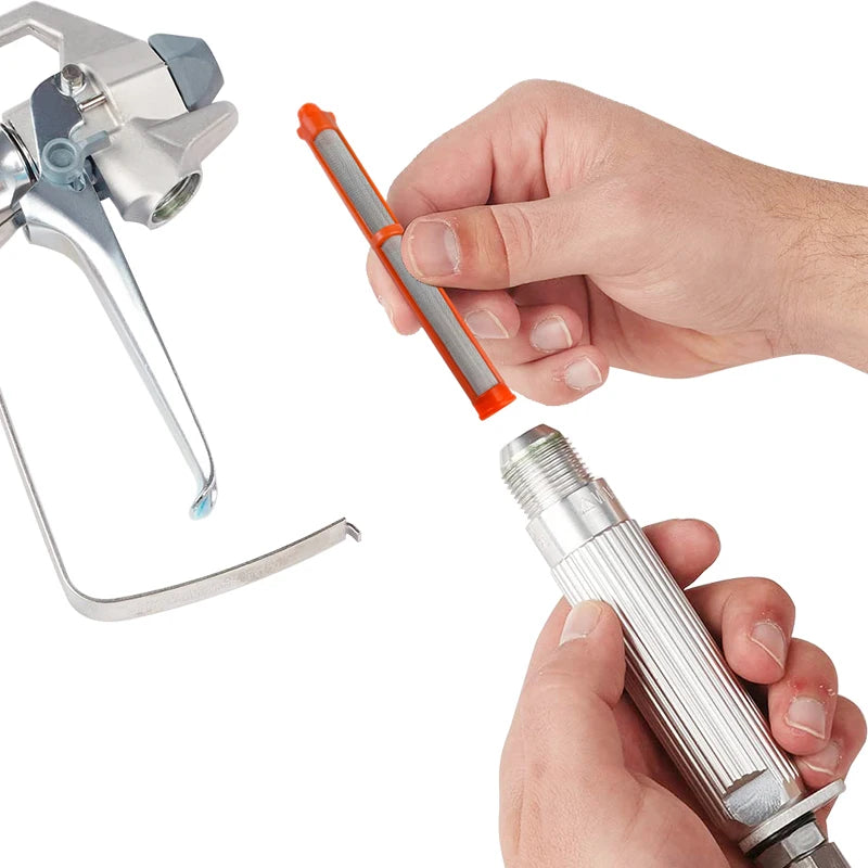 Eine Hand hält ein Filterset für eine luftlose Sprühmaschine, mit einer Metalldüse und einem orangefarbenen Filterstab.