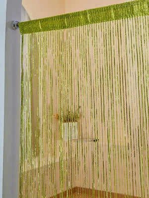 A sheer gold tassel string curtain hanging vertically, used as a room divider or doorway drape.