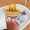 A hand holds a silicone bear finger puppet bath toy and an elephant finger puppet bath toy in a white bowl.