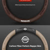 A close-up view of a brown carbon fiber patterned nappa skin steering wheel cover for a Nissan vehicle.