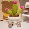 A cute artificial flower plush doll resembling a cactus with green body and pink fuzzy flowers sitting in a white pot.