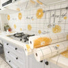 A kitchen splashback featuring white subway tiles decorated with yellow citrus fruit designs.