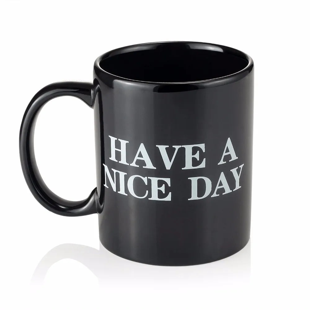 Una taza de café negra con el texto 'HAVE A NICE DAY' impreso.
