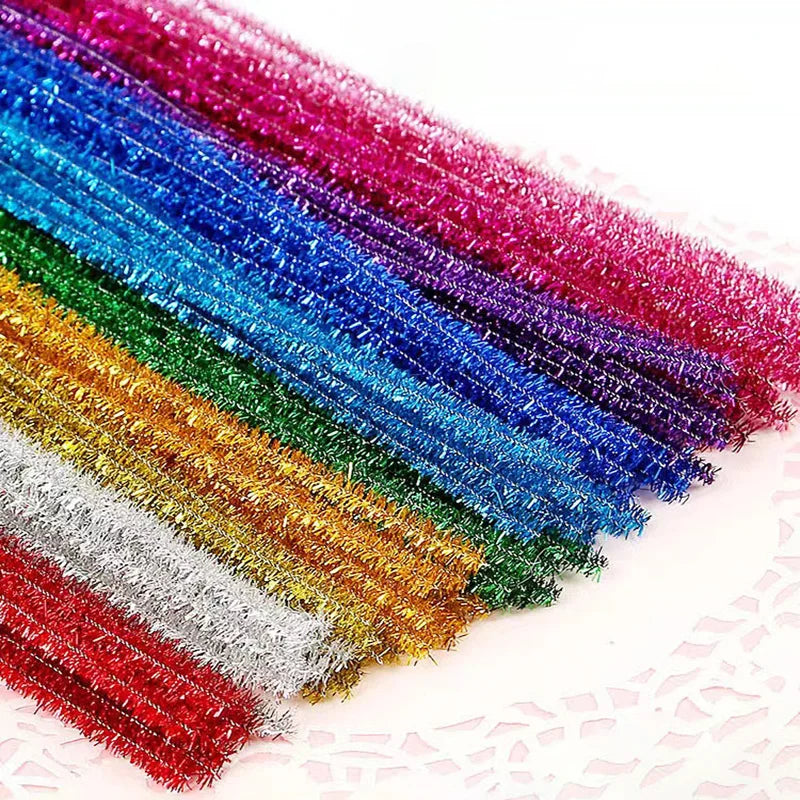 A vibrant rainbow of colorful chenille craft stems arranged diagonally on a white background.