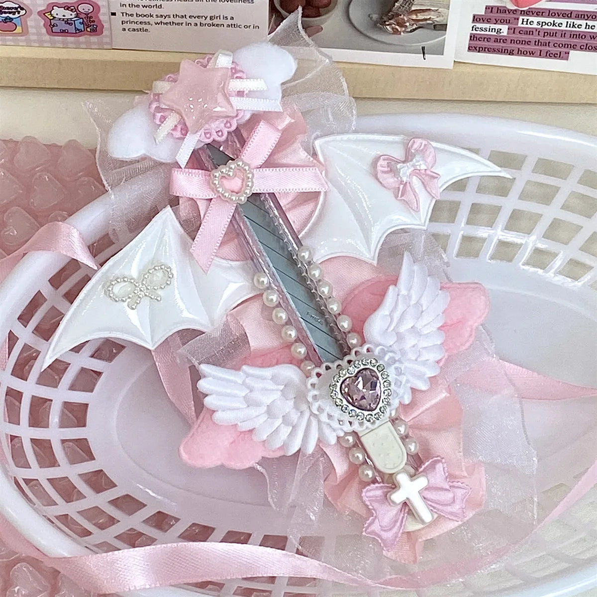 A pink and white decorative utility cutter featuring a cat paw design with a sparkling blade and pink ribbon accents.