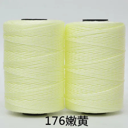 Two spools of light yellow 3-ply polyester knitting yarn for crochet and hand crafts