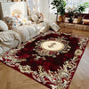 A burgundy and gold floral medallion area rug with ornate detailing placed on a wooden floor.
