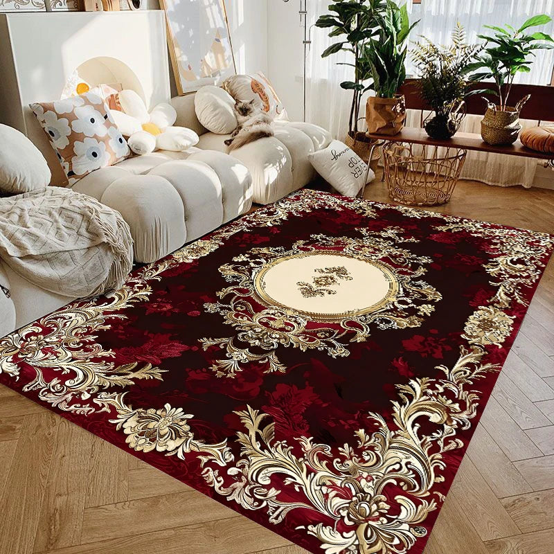 A burgundy and gold floral medallion area rug with ornate detailing placed on a wooden floor.