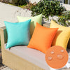 A collection of colorful linen-textured outdoor pillow covers in shades of turquoise, lime green, orange, and yellow displaye