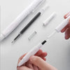 A hand holds a white retractable gel pen and several other black pens with silver springs on a white background.