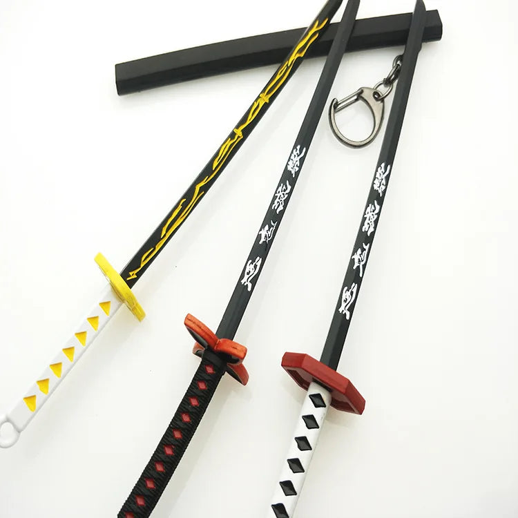 A replica Demon Slayer mini katana sword with a black handle, yellow hilt, and white blade, displayed against a white backgro