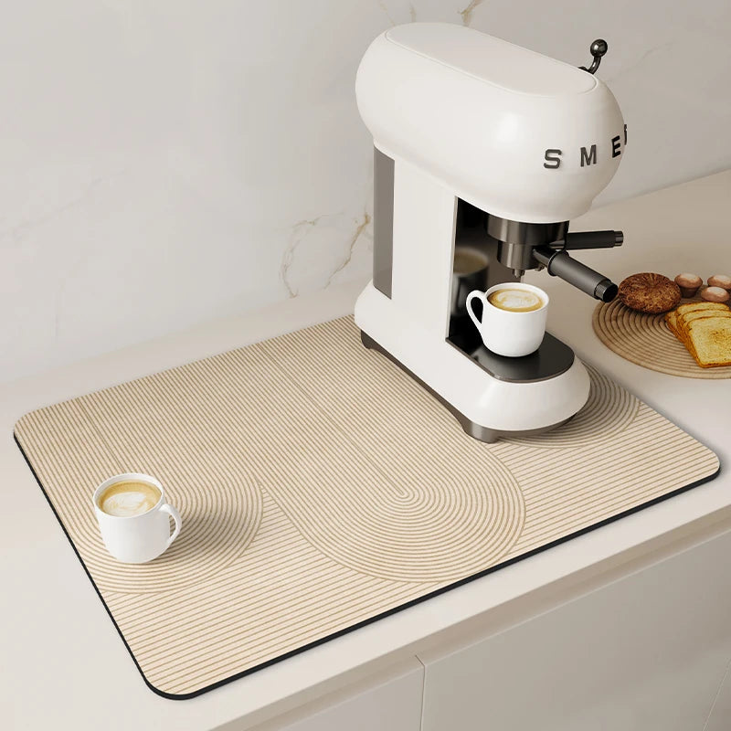 A white espresso machine sits on a beige counter mat with concentric circles, next to some bread.