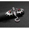 Silver enamel dragon brooch with rhinestone accents displayed on a dark background.